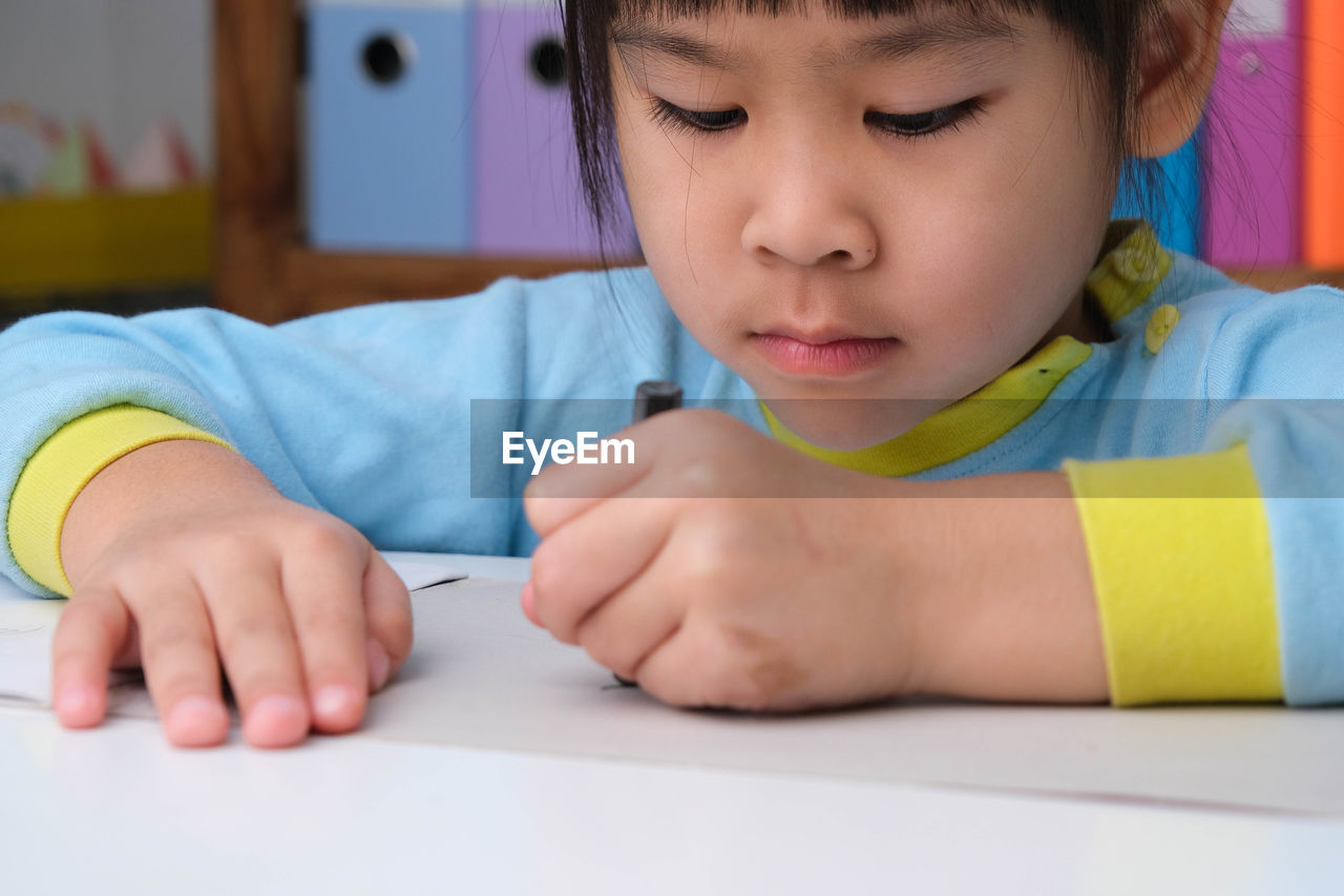 close-up of boy drawing on book at home