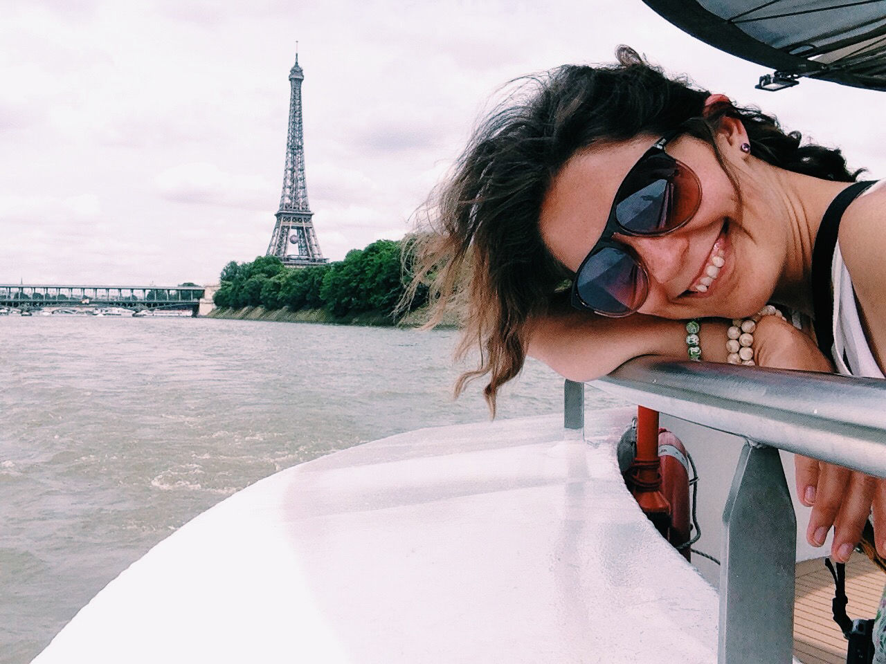 Portrait of woman traveling in boat against eiffel tower