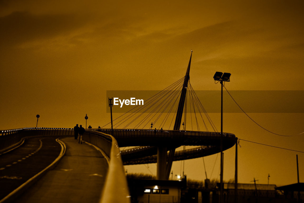 Silhouette bridge against sky during sunset