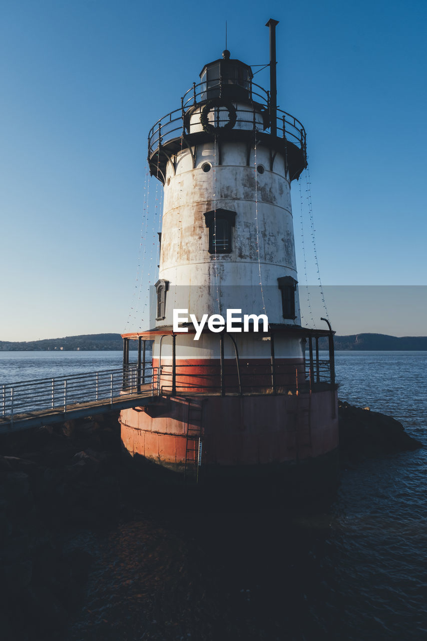 LIGHTHOUSE BY SEA AGAINST SKY