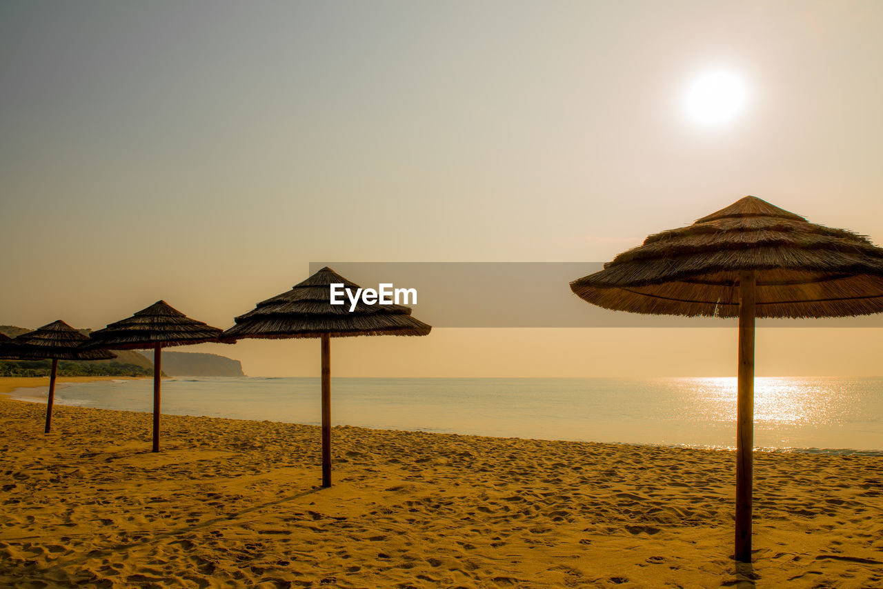 scenic view of beach against clear sky during sunset