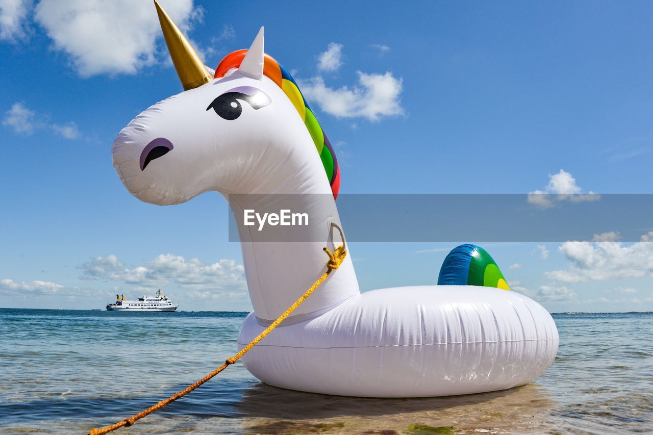 Inflatable ring at beach against sky