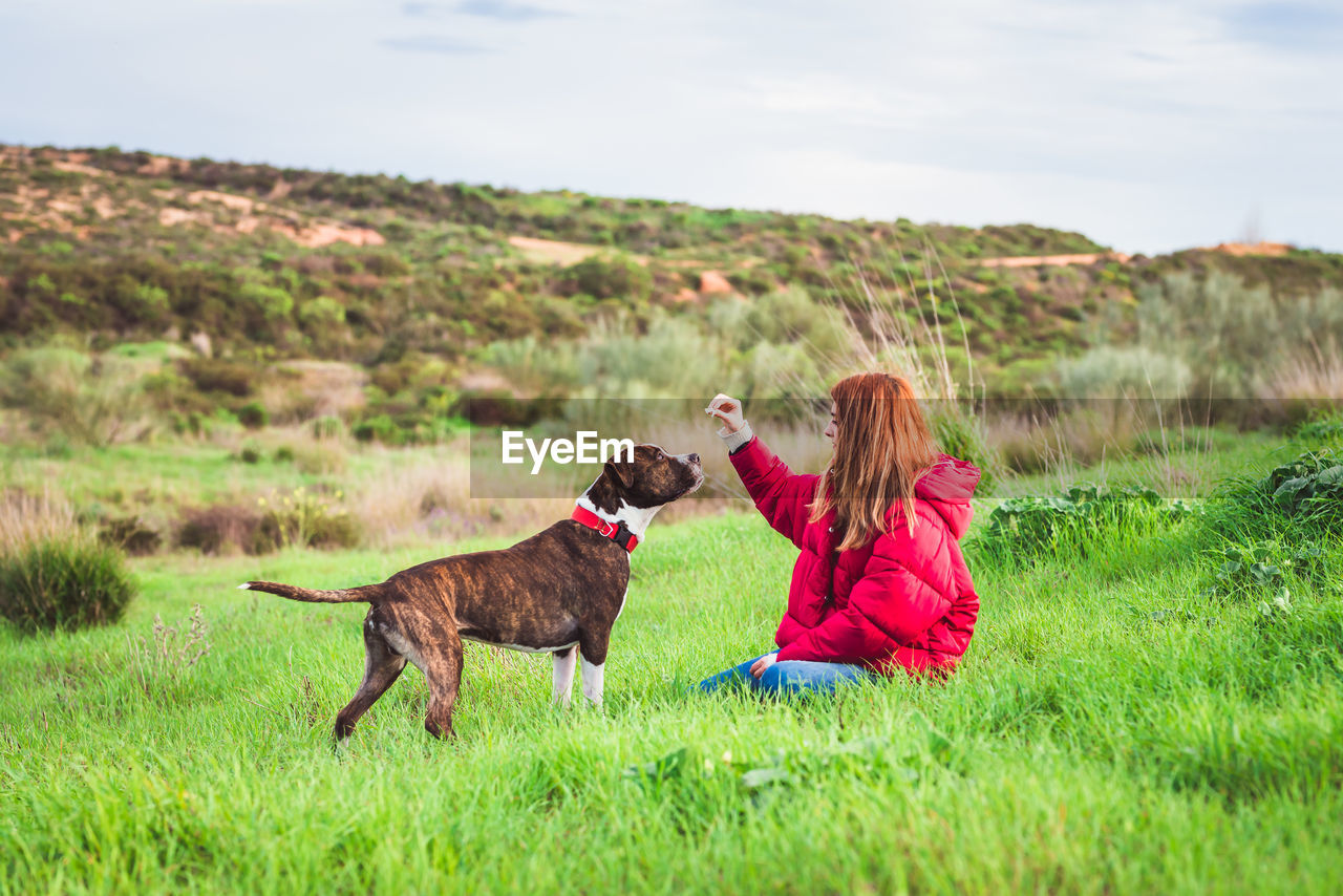 Woman with dog on field