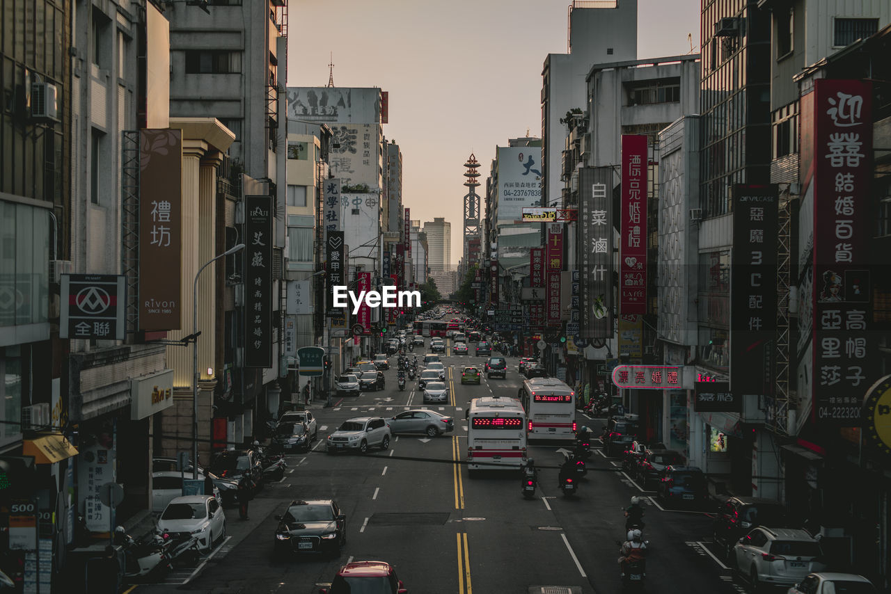 Traffic on road amidst buildings in city