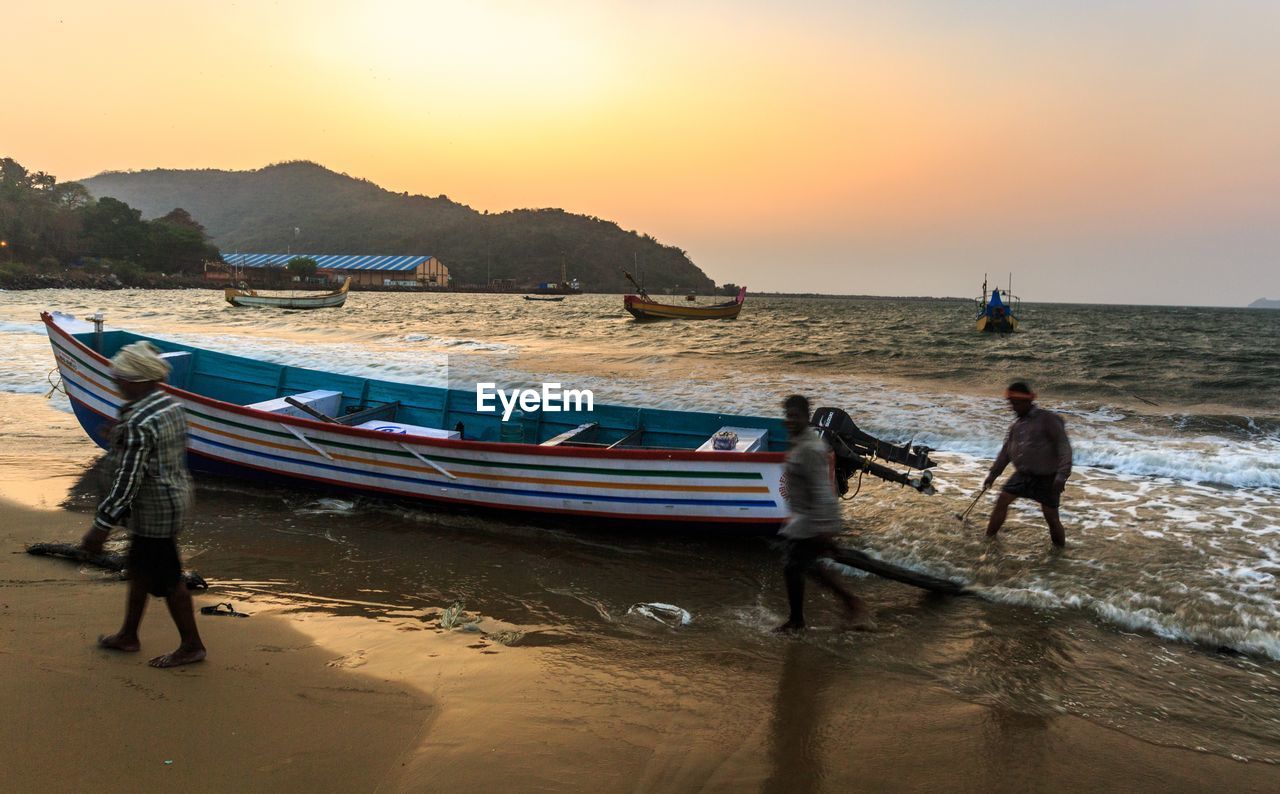 PEOPLE ON BEACH DURING SUNSET