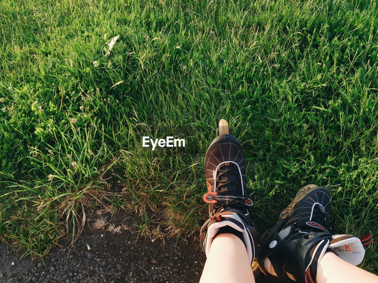 Low section of person wearing roller skates on grassy field