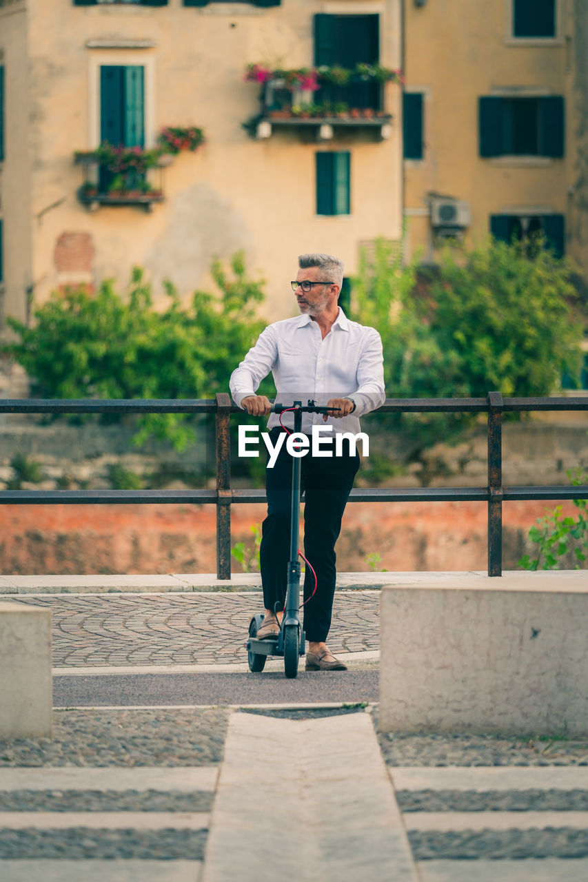 Full length of man standing against wall in city