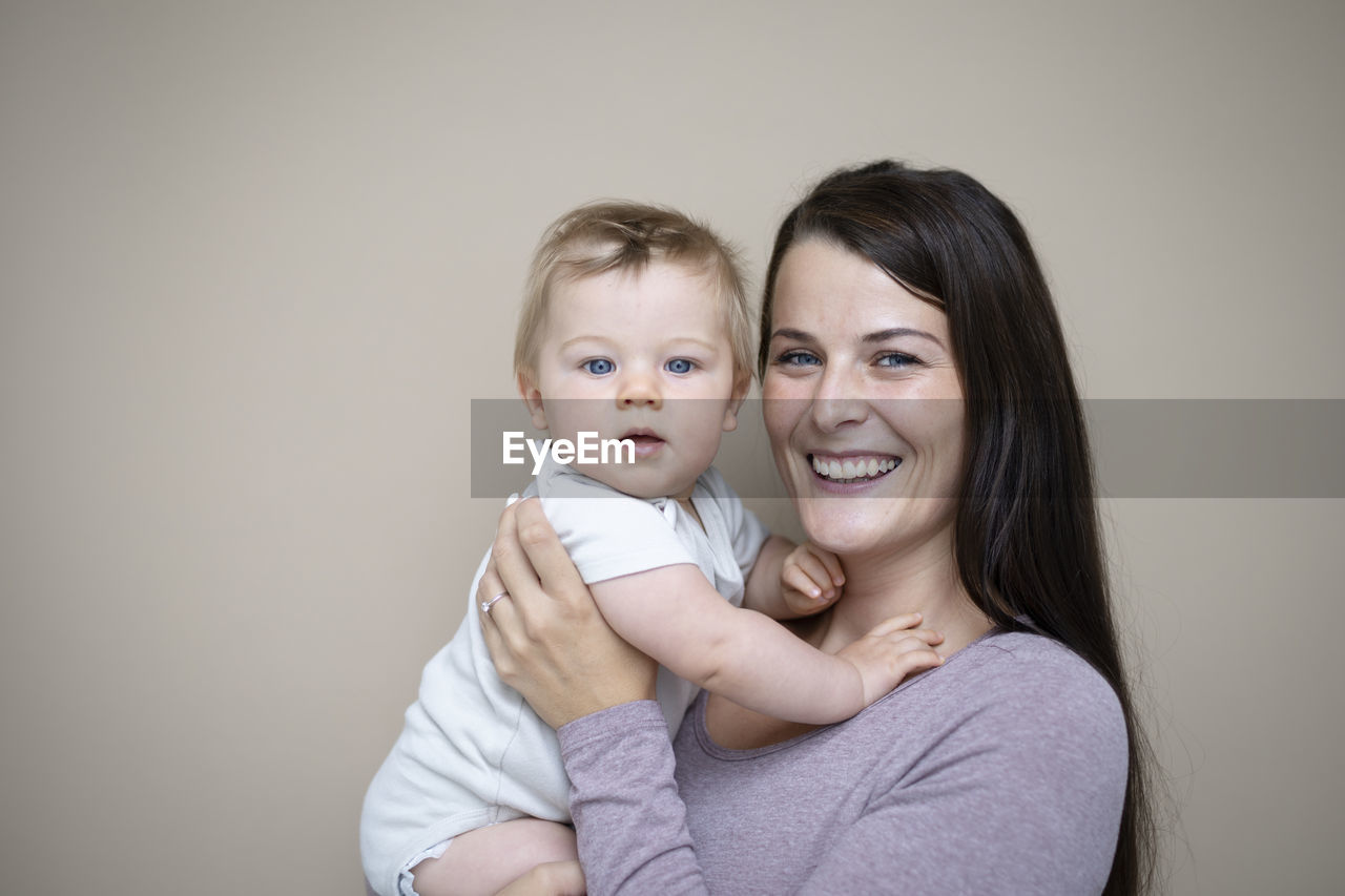 portrait of mother carrying daughter