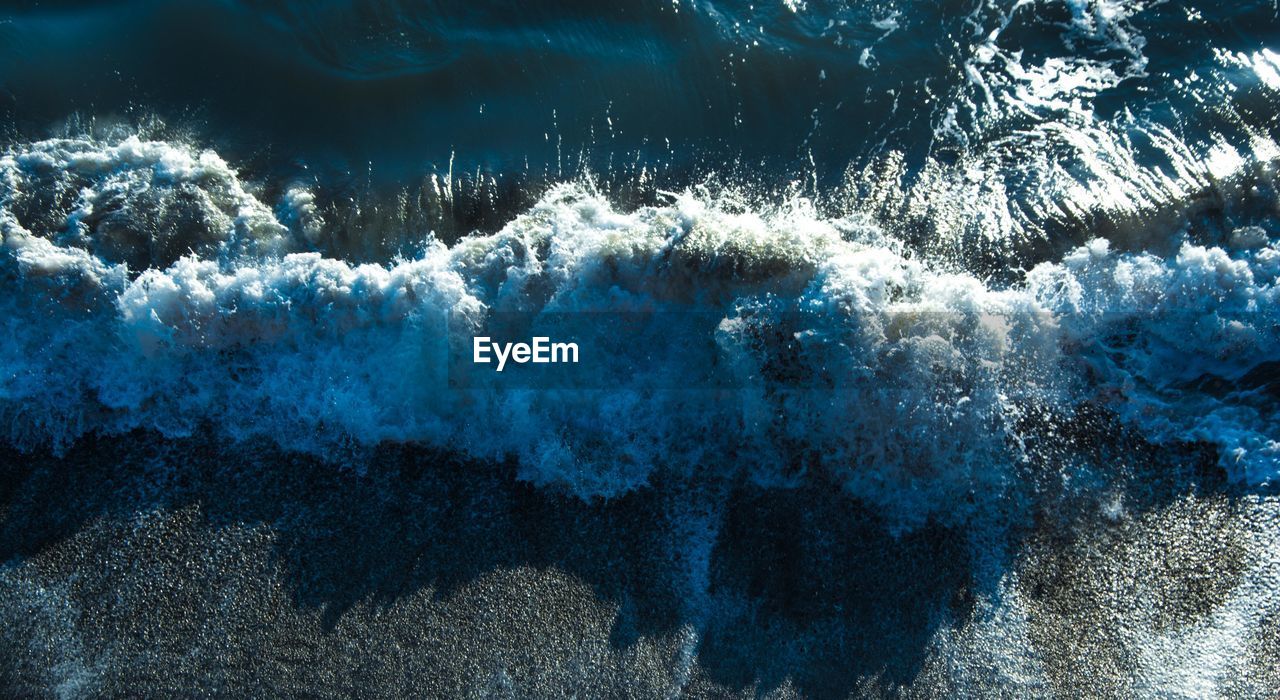 HIGH ANGLE VIEW OF SEA WAVES SPLASHING