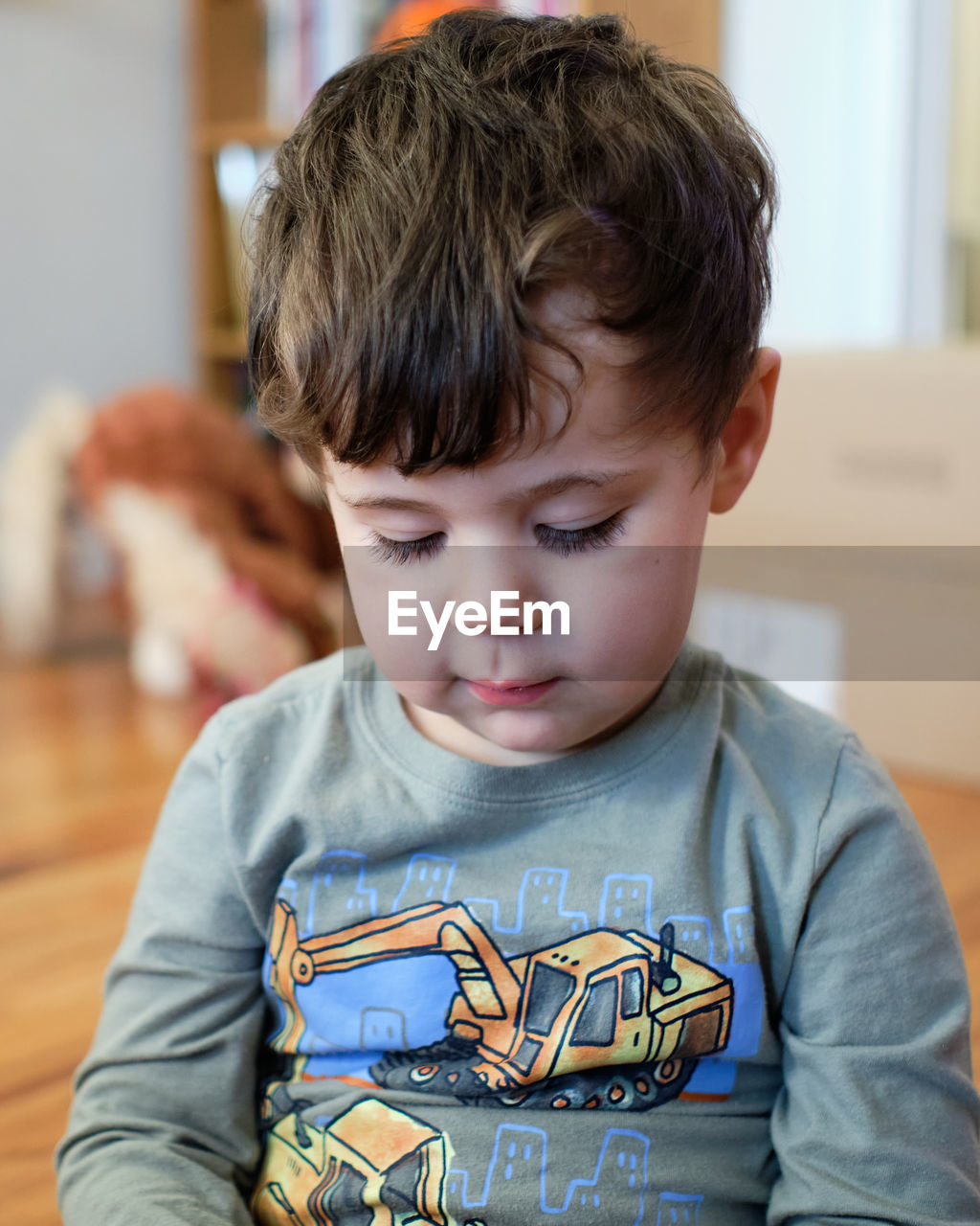 Portrait of a young boy of three playing with a toy in the living room