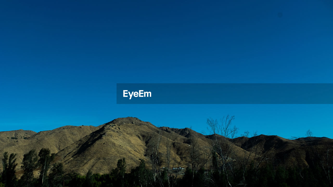 LOW ANGLE VIEW OF MOUNTAIN AGAINST BLUE SKY