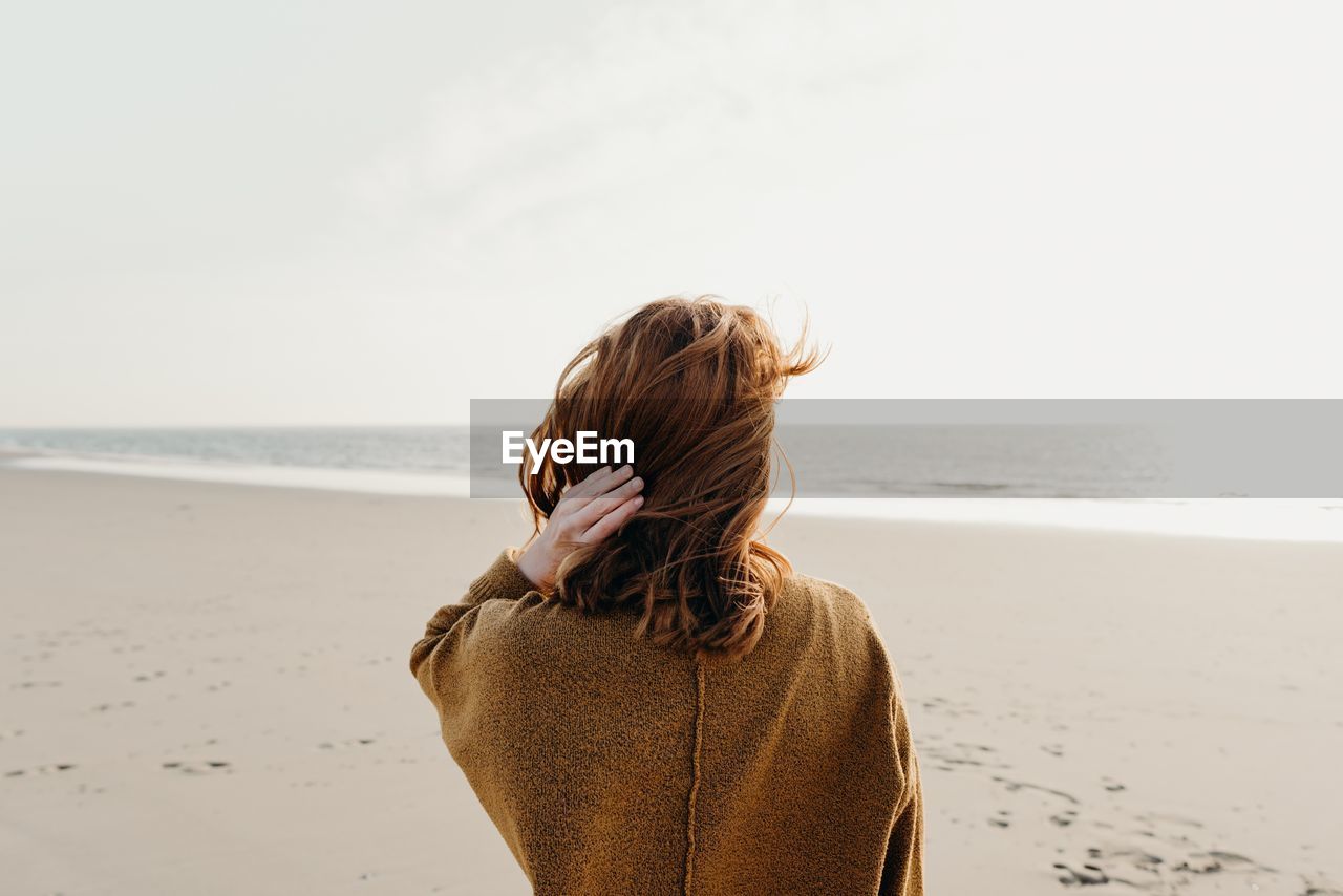 Rear view of woman standing on beach