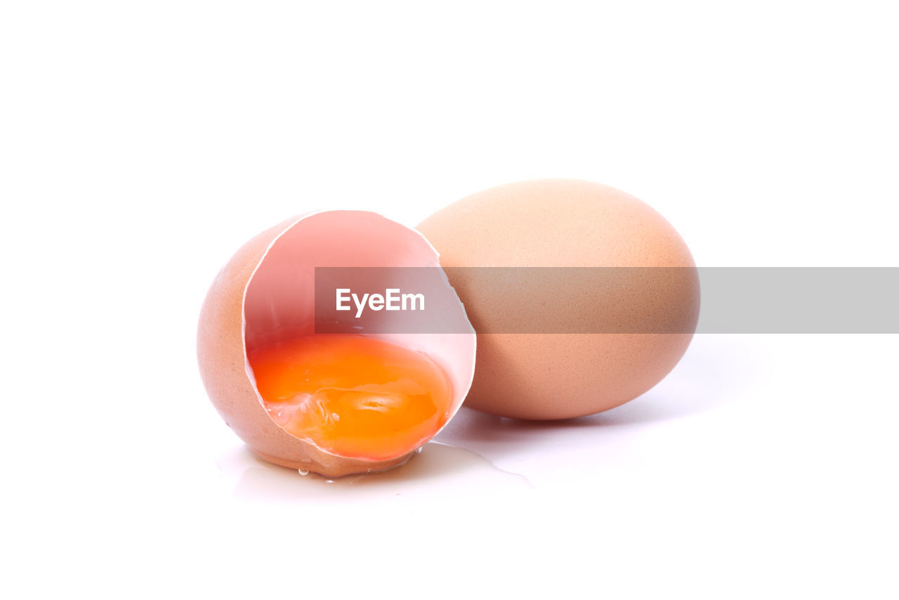 Close-up of golden yolk egg against white background