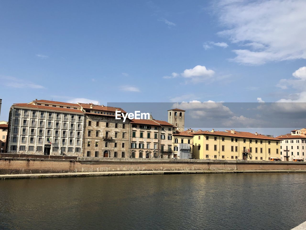 BUILDINGS BY RIVER AGAINST SKY