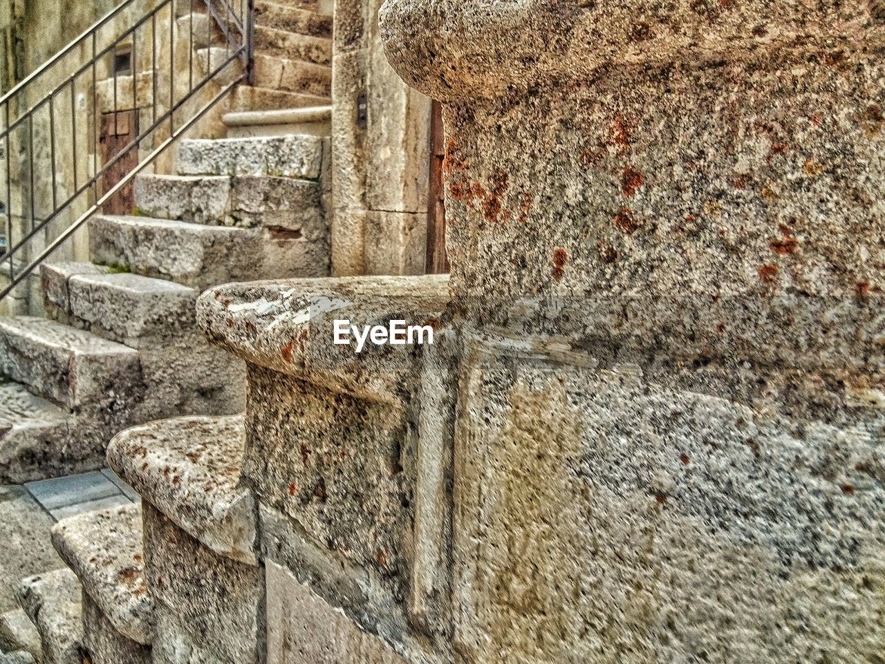 STONE WALL WITH BRICK WALL IN BACKGROUND