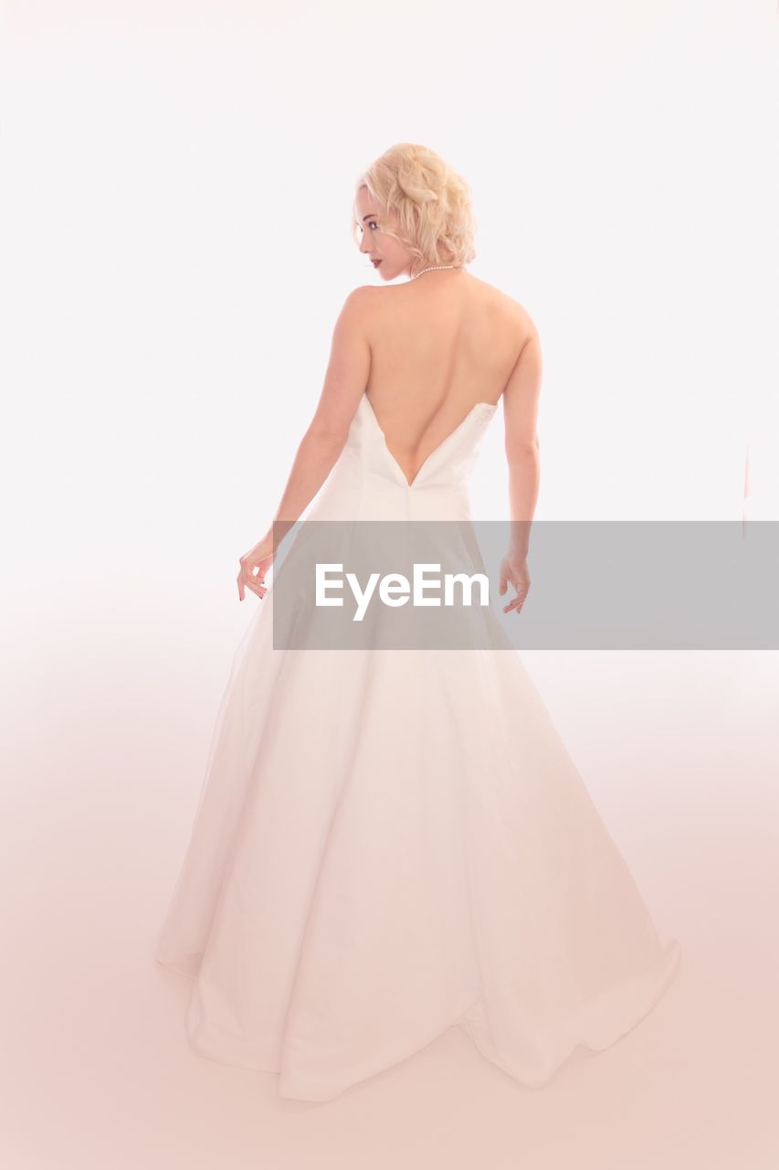 Rear view of woman wearing dress against white background