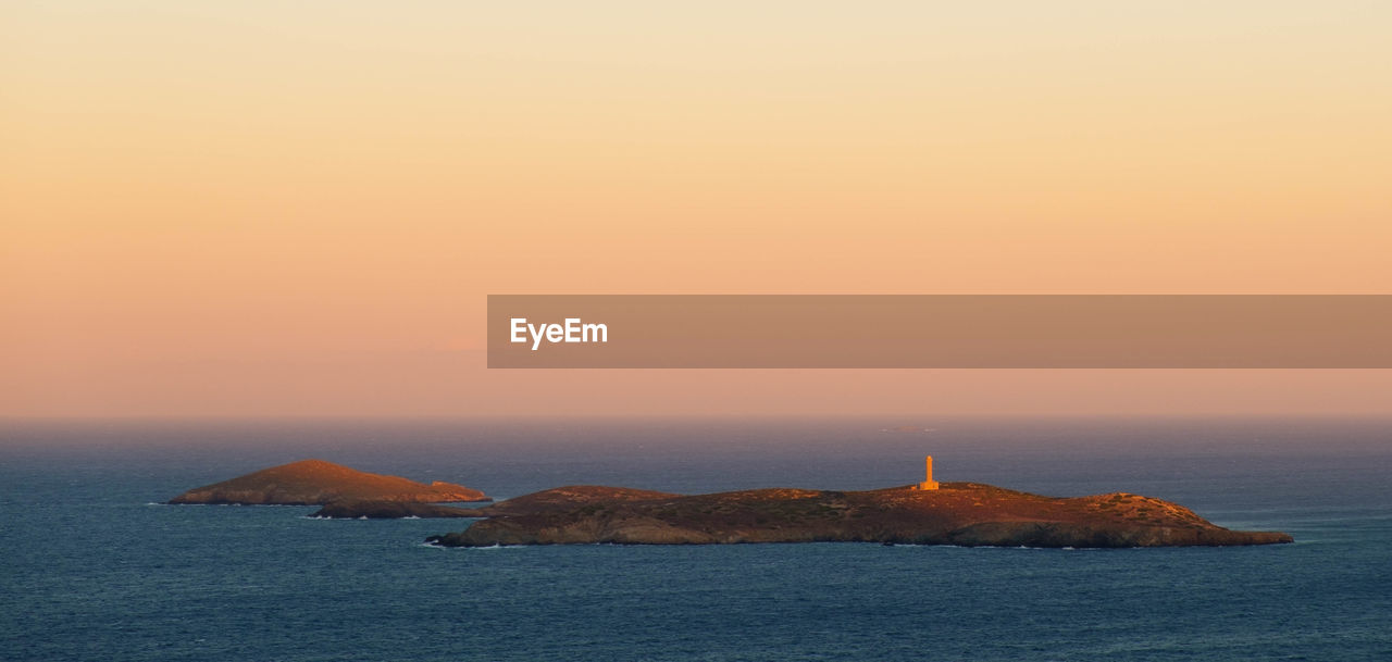 Scenic view of an island against sky during sunset