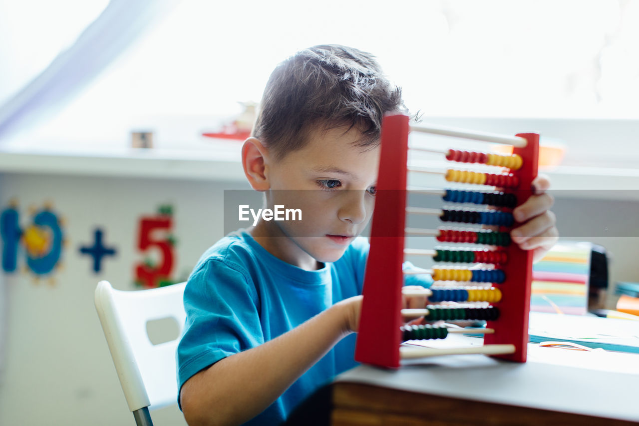 Close-up of boy using abacus