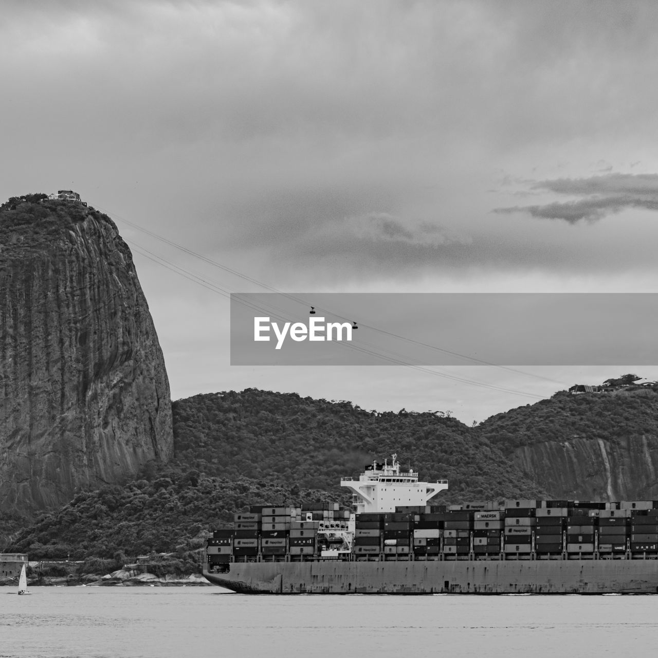 Photo of sugarloaf mountain with a cargo ship passing in front of it in guanabara bay