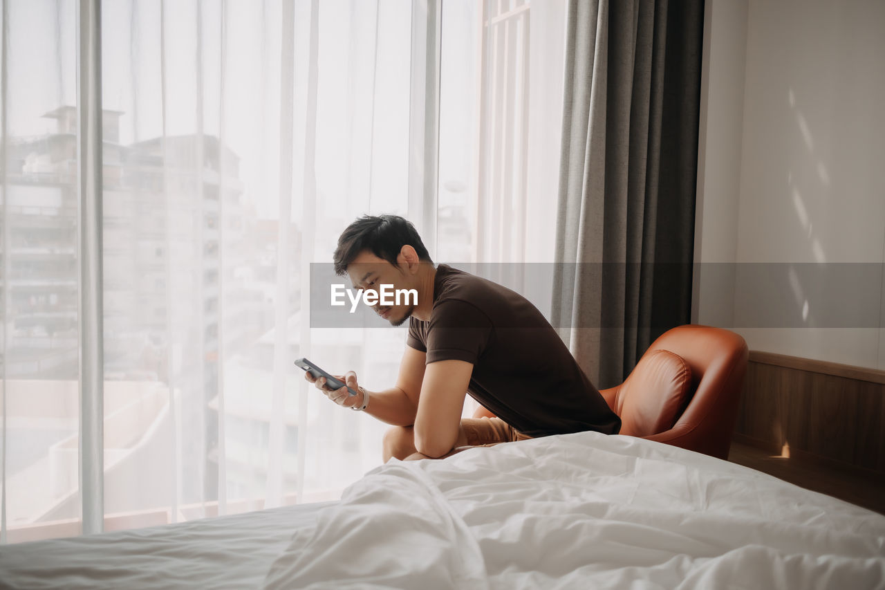 Young woman using laptop on bed at home