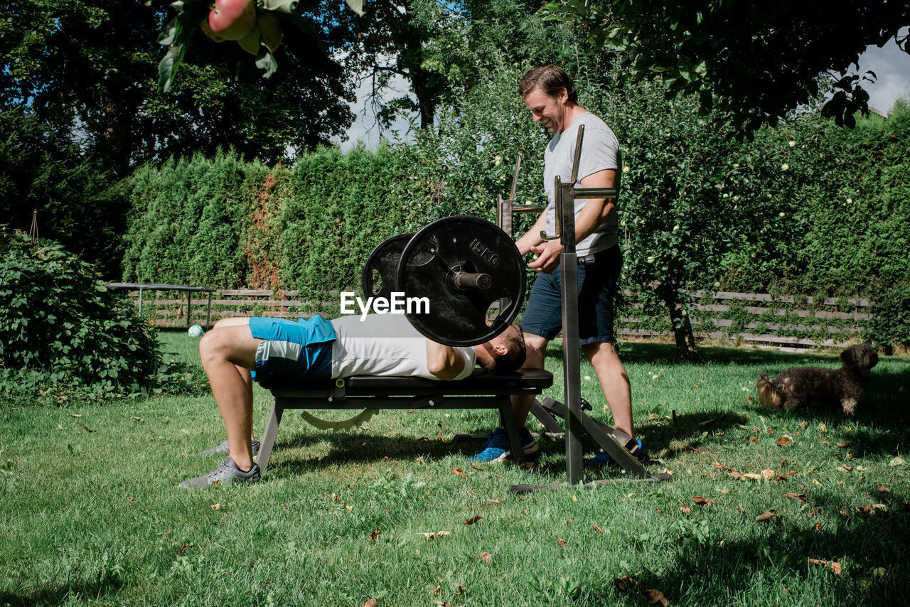 Two men working out together at home in the garden gym