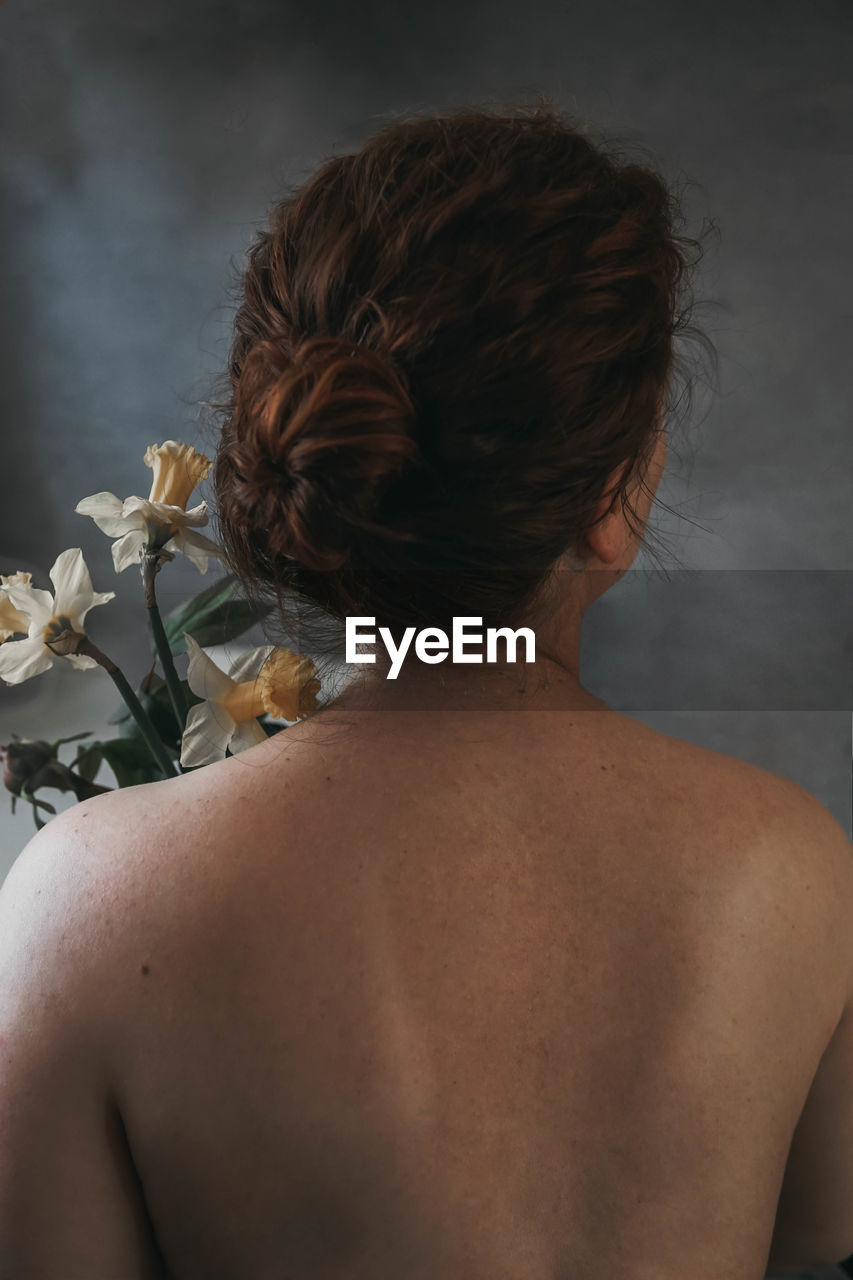 Rear view of woman while holding flowers