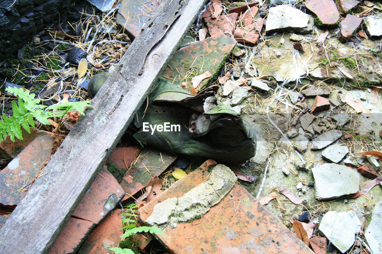 Abandoned torn shoe and broken tiles on floor