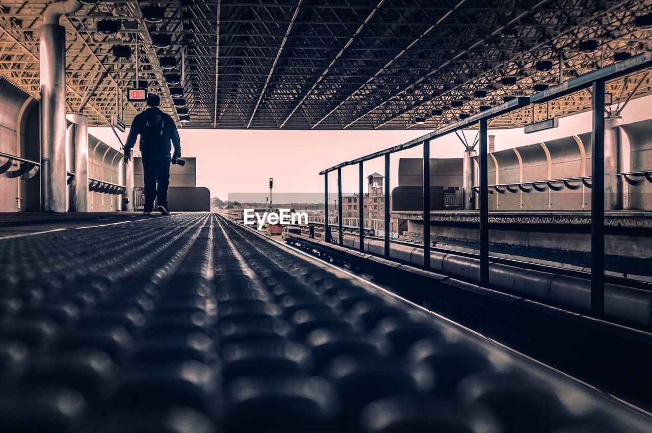 Surface level shot of man walking on railroad station platform