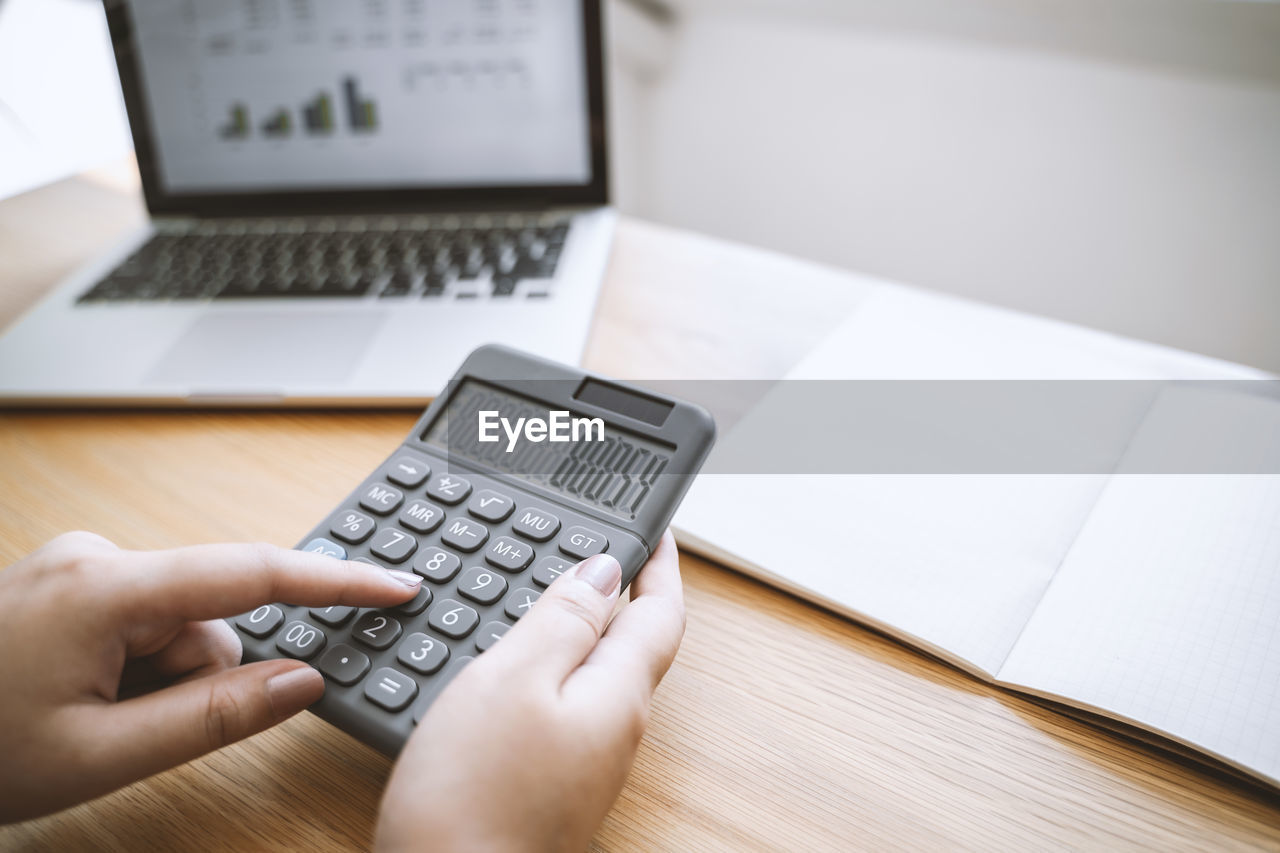 High angle view of person using calculator on table
