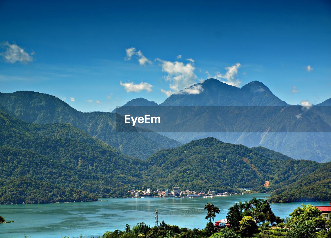 Scenic view of sea and mountains against sky