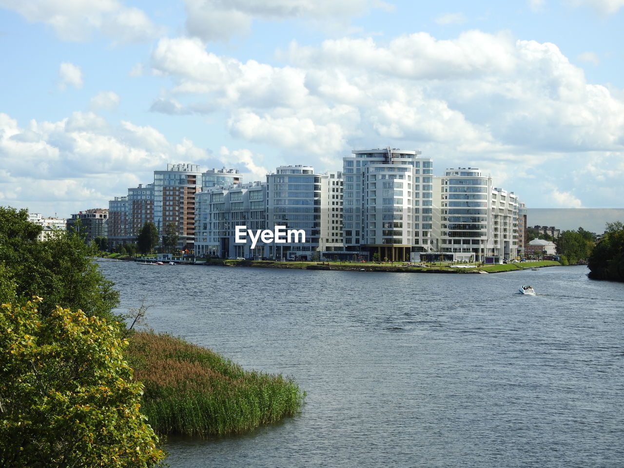 Buildings by sea against sky in city