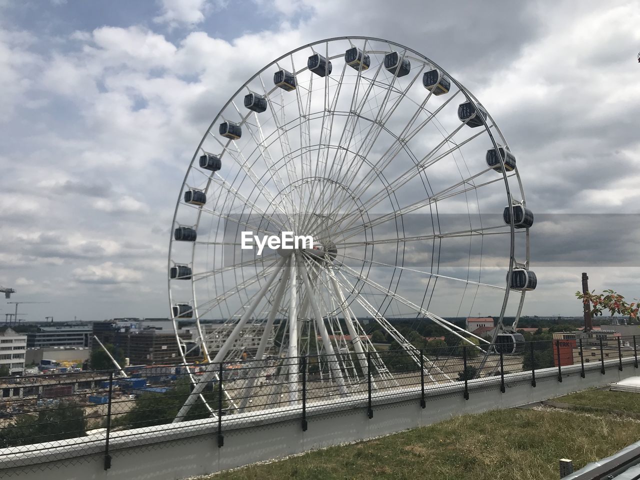 FERRIS WHEEL BY CITY AGAINST SKY