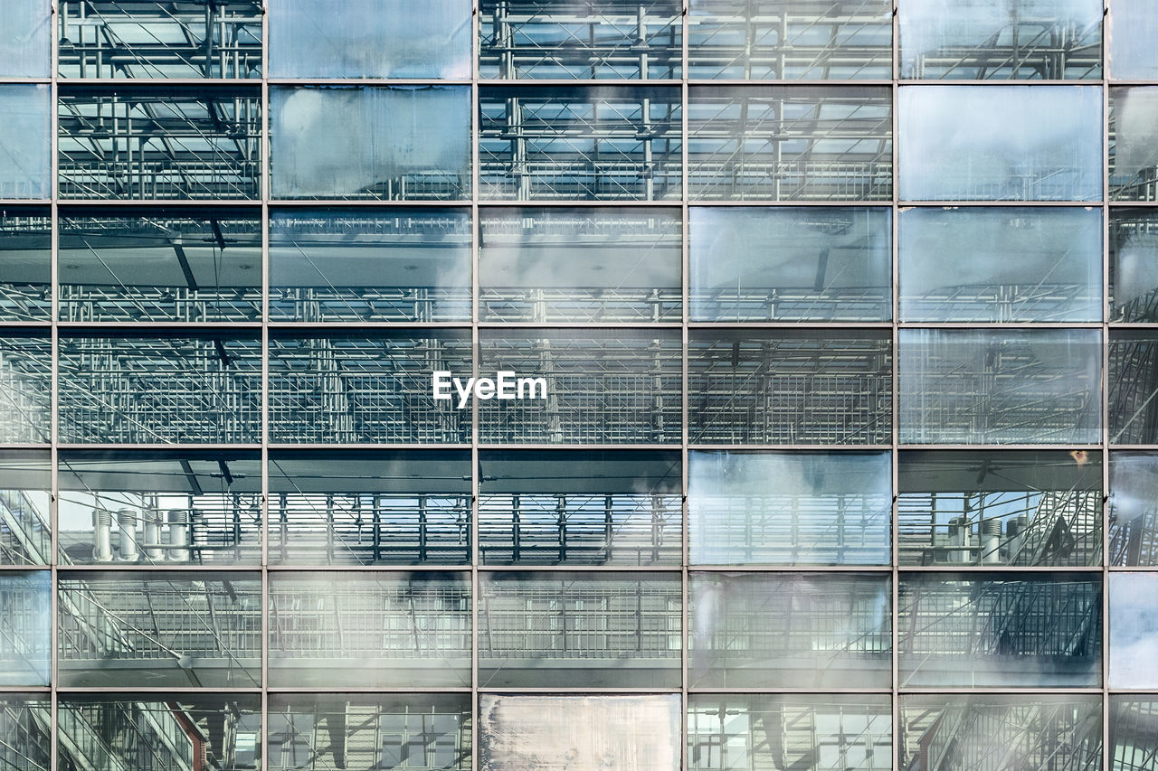 Low angle view of glass building against sky