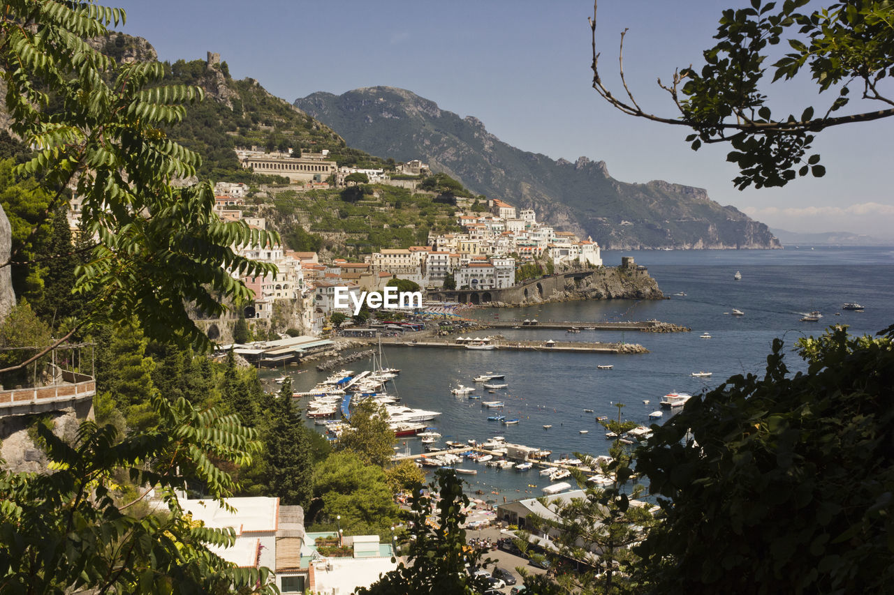 Scenic view of town by sea against sky