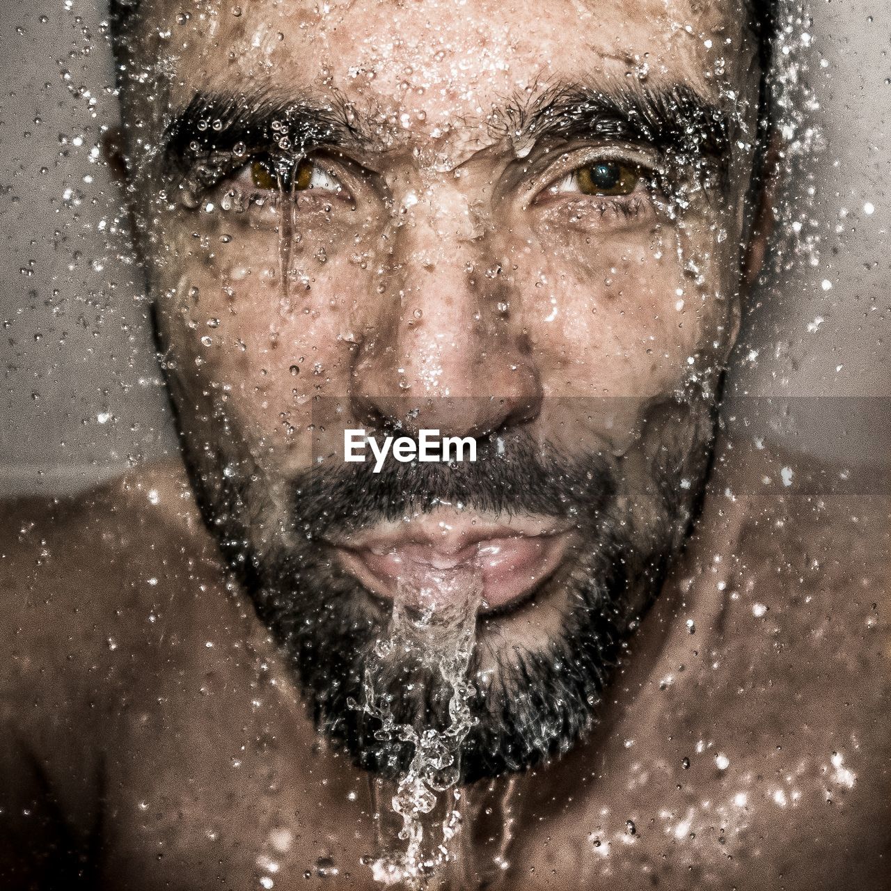 Close-up portrait of mature man spitting water