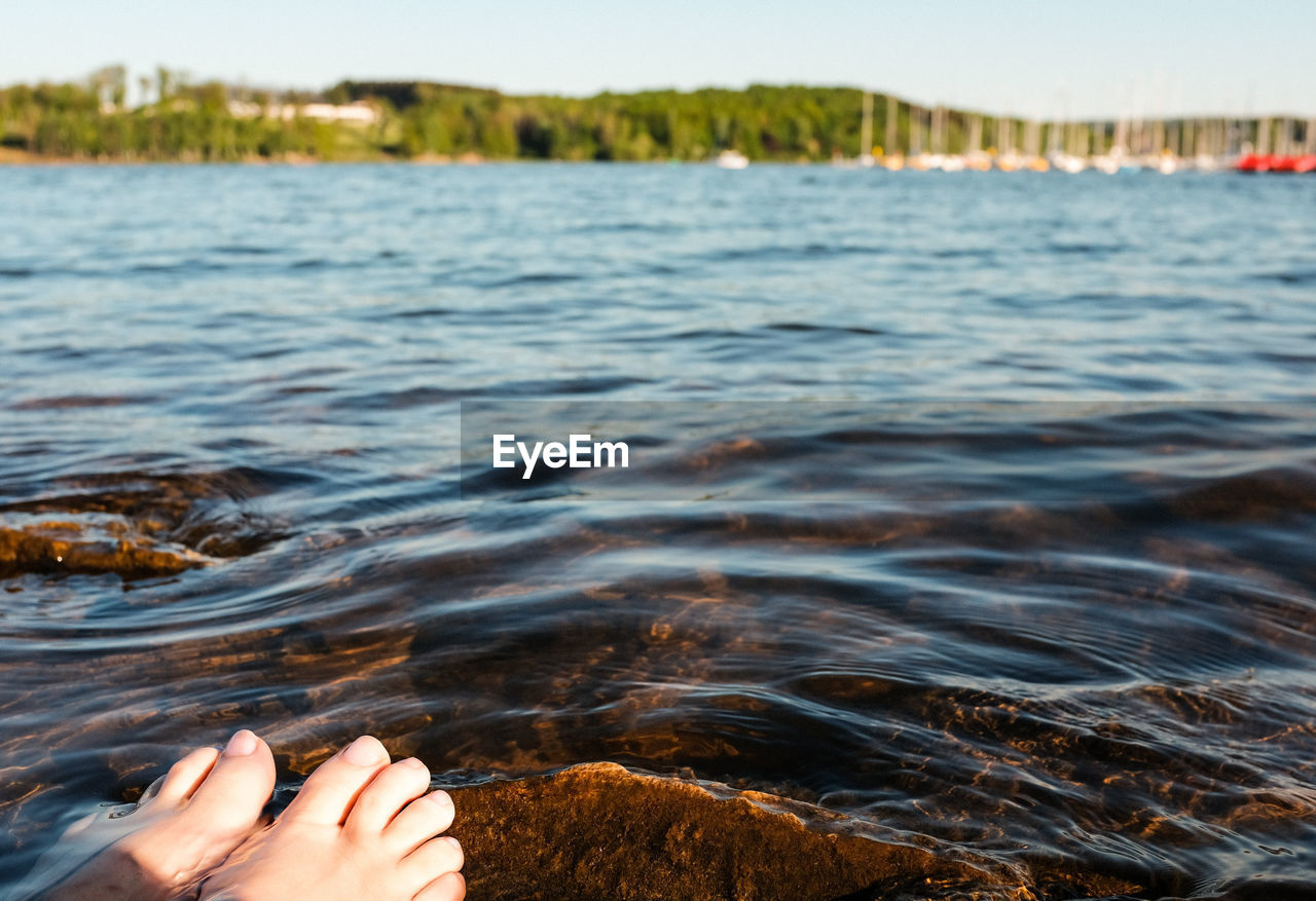 LOW SECTION OF PERSON ON SEA WATER