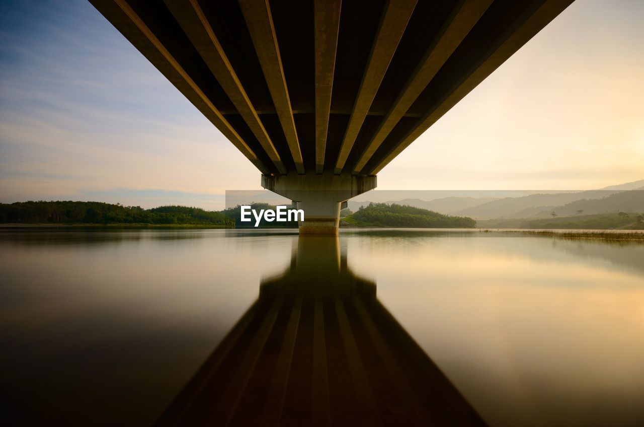 Bridge over river against sky during sunset