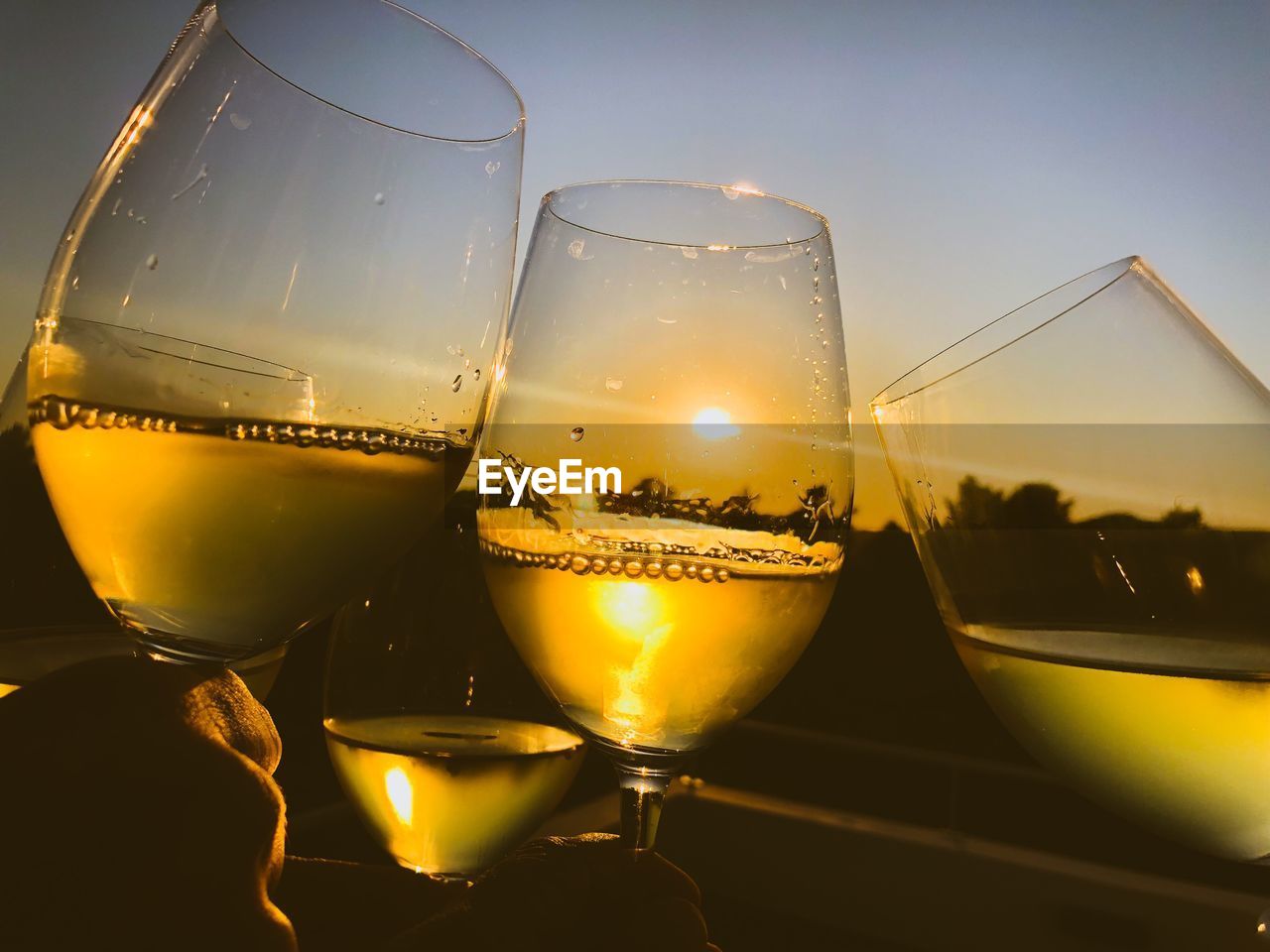 Close-up of wine glass on table at sunset