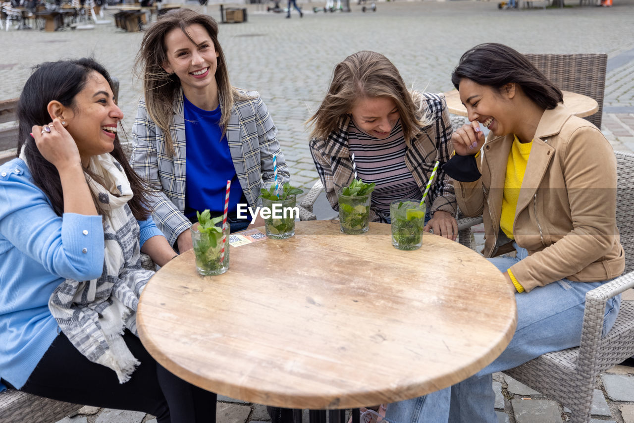 group of friends toasting drinks at table