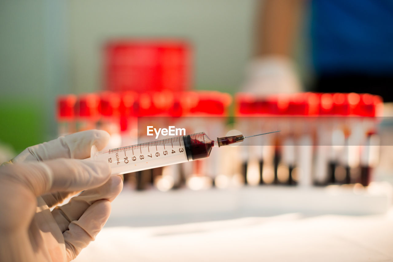 Cropped hand of doctor holding syringe at hospital