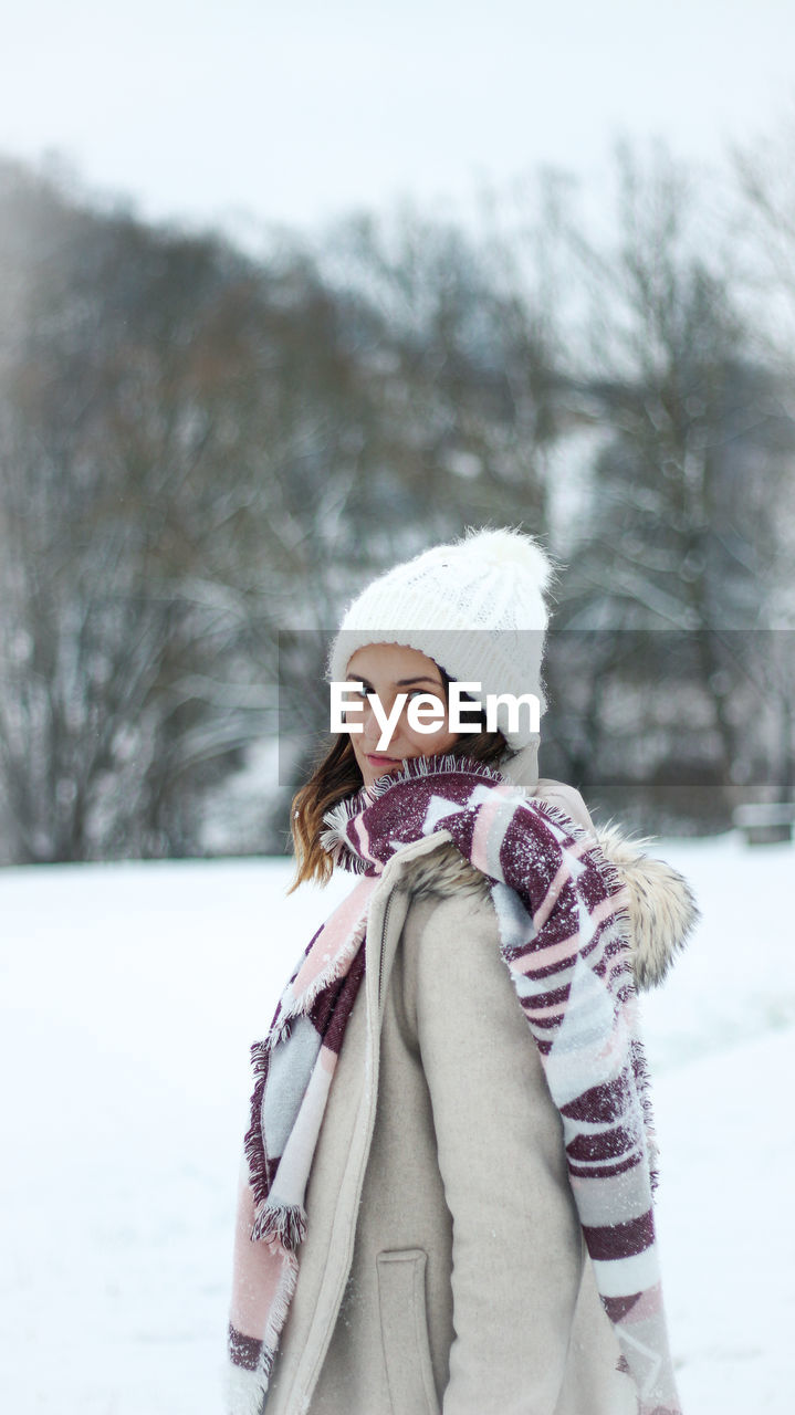 Portrait of young woman standing in snow