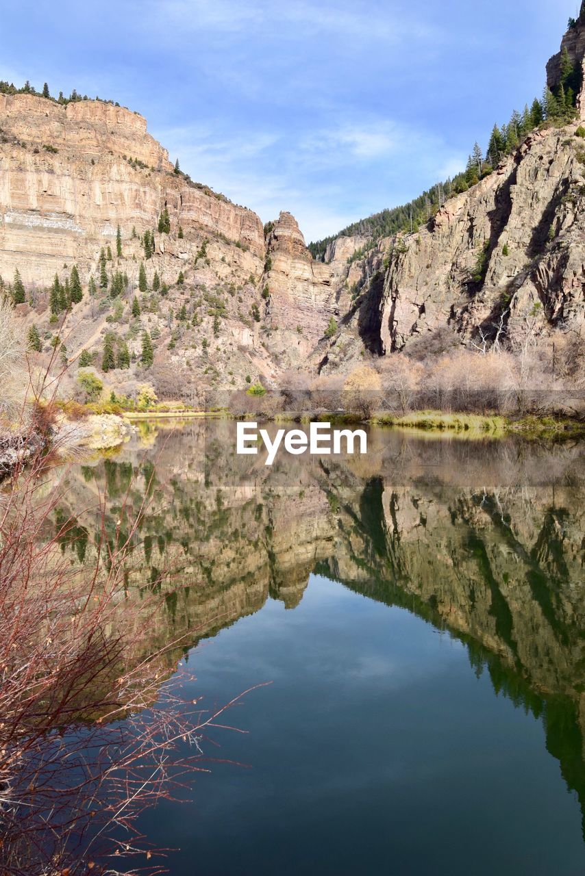 Scenic view of lake by mountains against sky