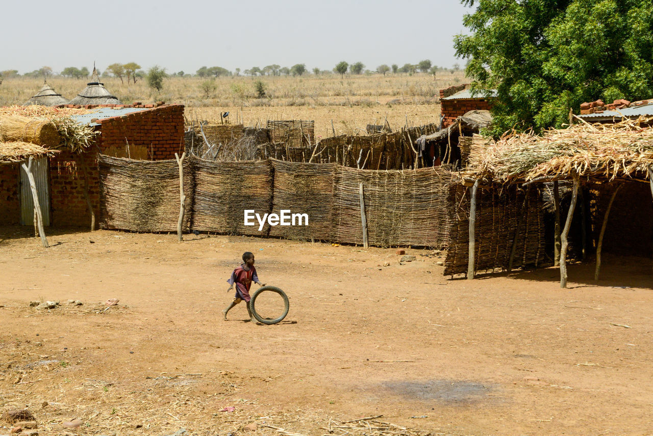 Boy playing with tire outdoors