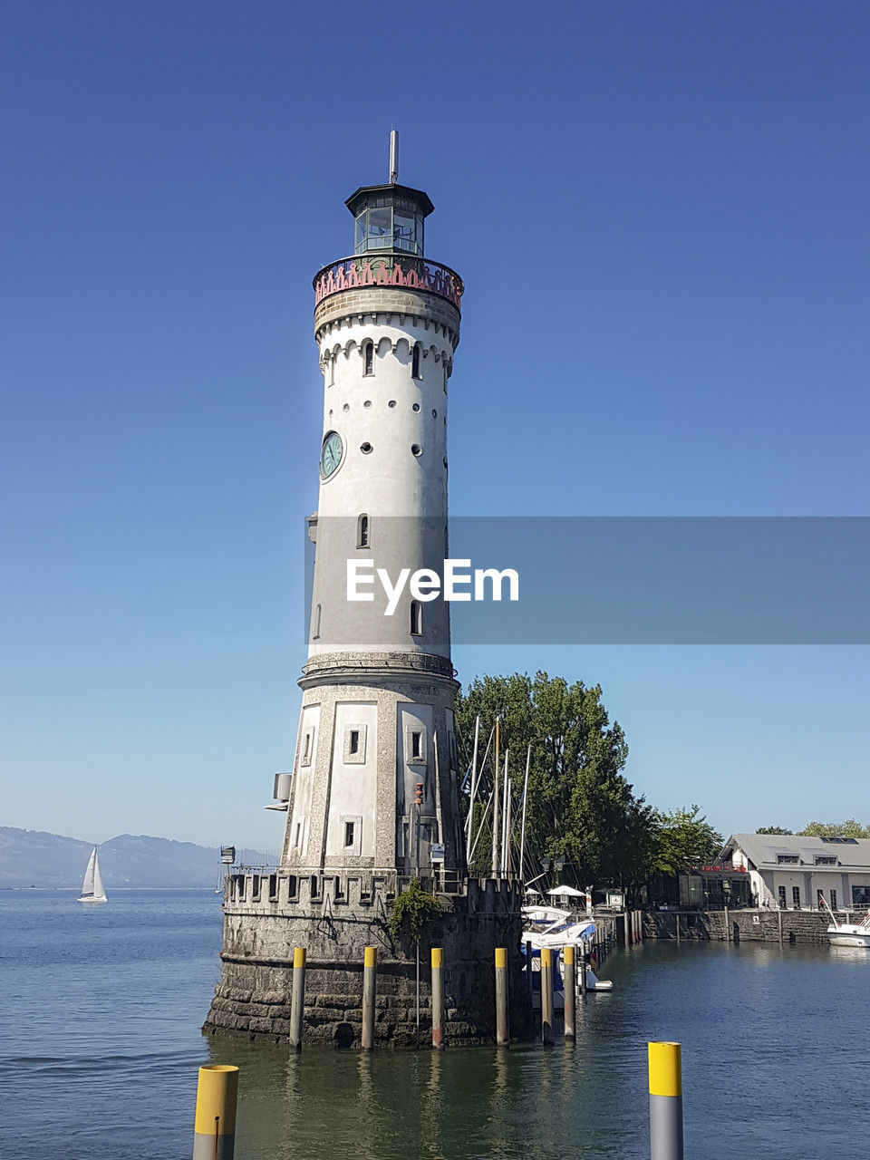 architecture, guidance, built structure, water, tower, lighthouse, building exterior, building, security, sky, sea, protection, nature, travel destinations, travel, nautical vessel, clear sky, blue, beach, transportation, no people, day, harbor, coast, coastline, outdoors, history, the past, land, tourism, observation tower, sunny, city