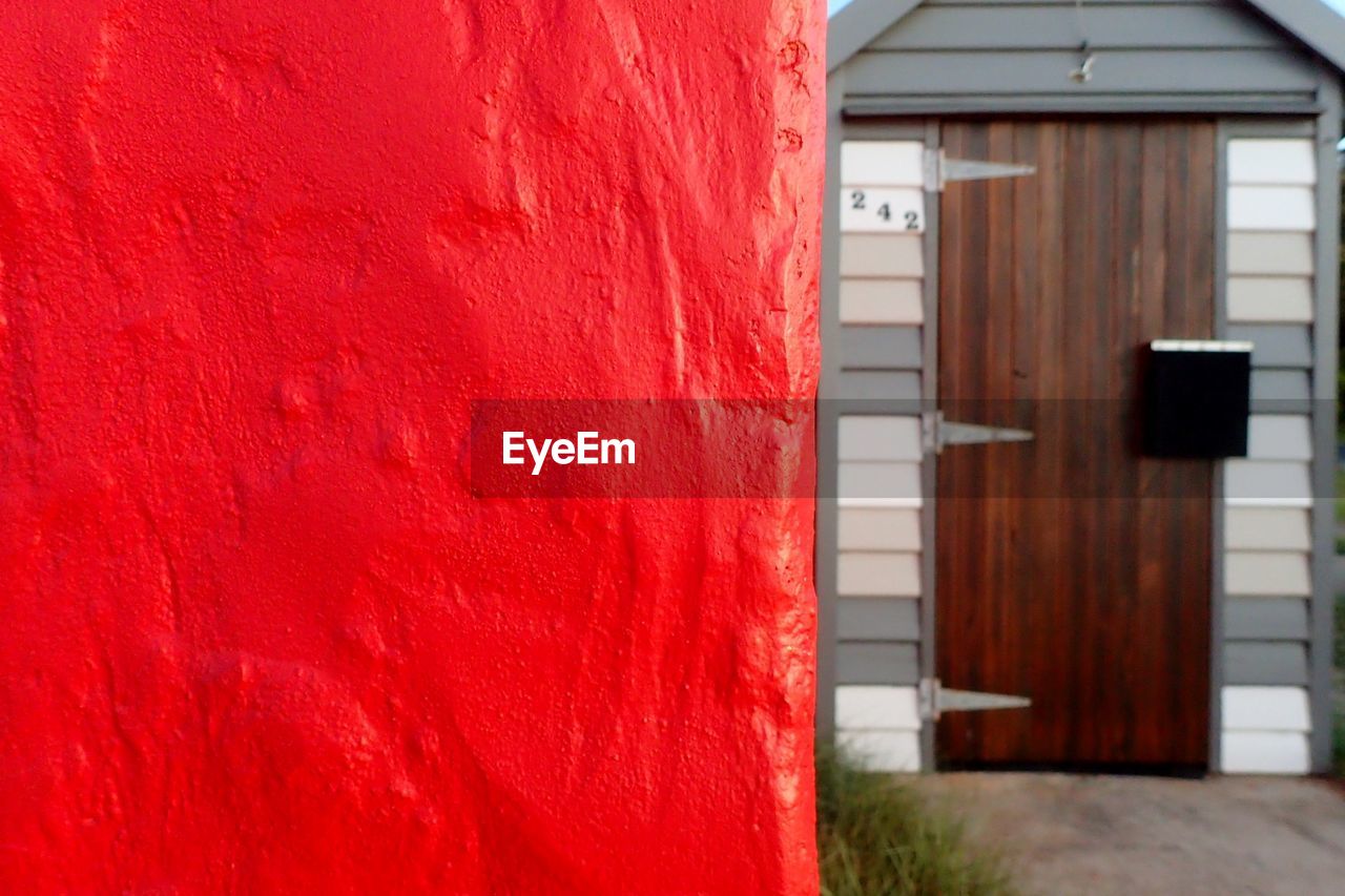 Close-up of red wall against door