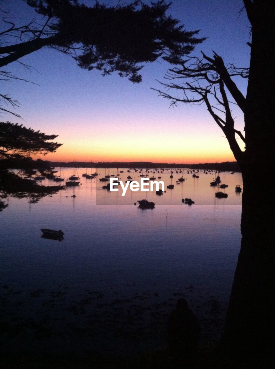 Scenic view of lake against sky at sunset