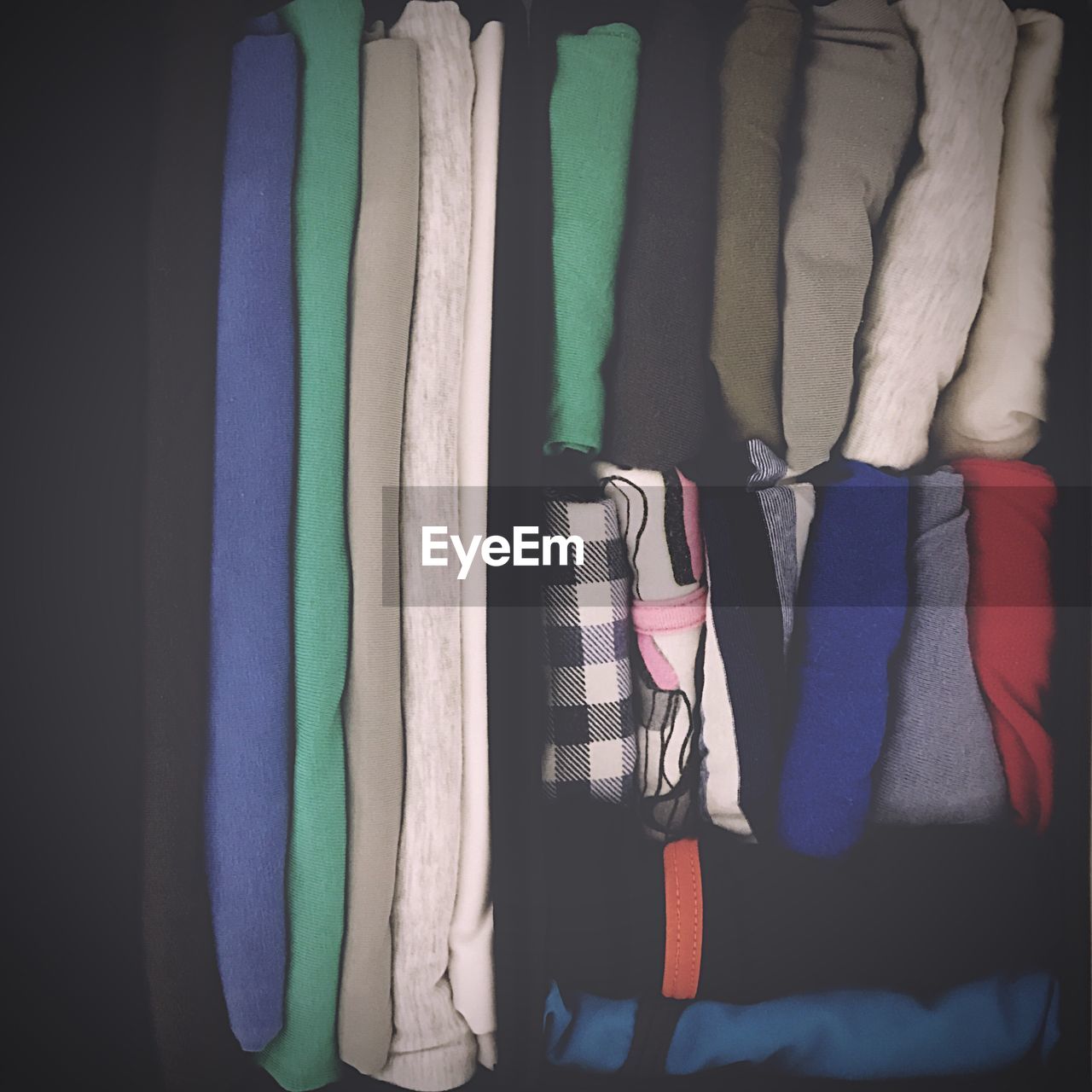 CLOSE-UP OF MULTI COLORED CLOTHES HANGING ON STORE
