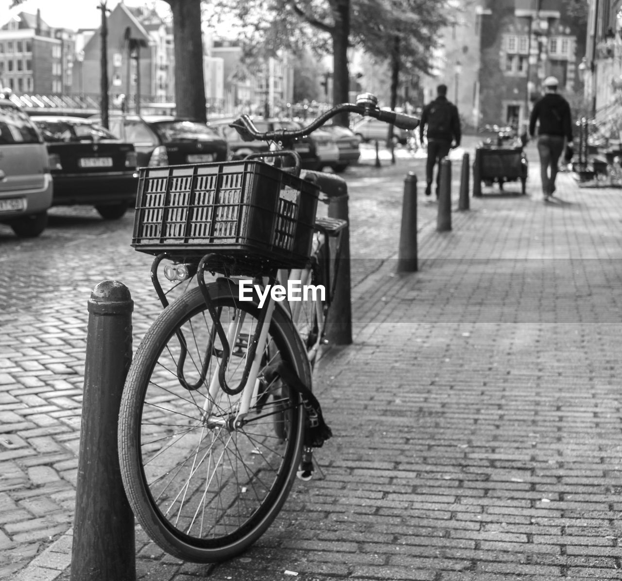 Bicycle by bollard on sidewalk