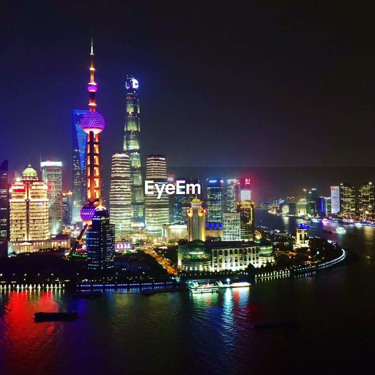 Illuminated buildings in city against sky at night