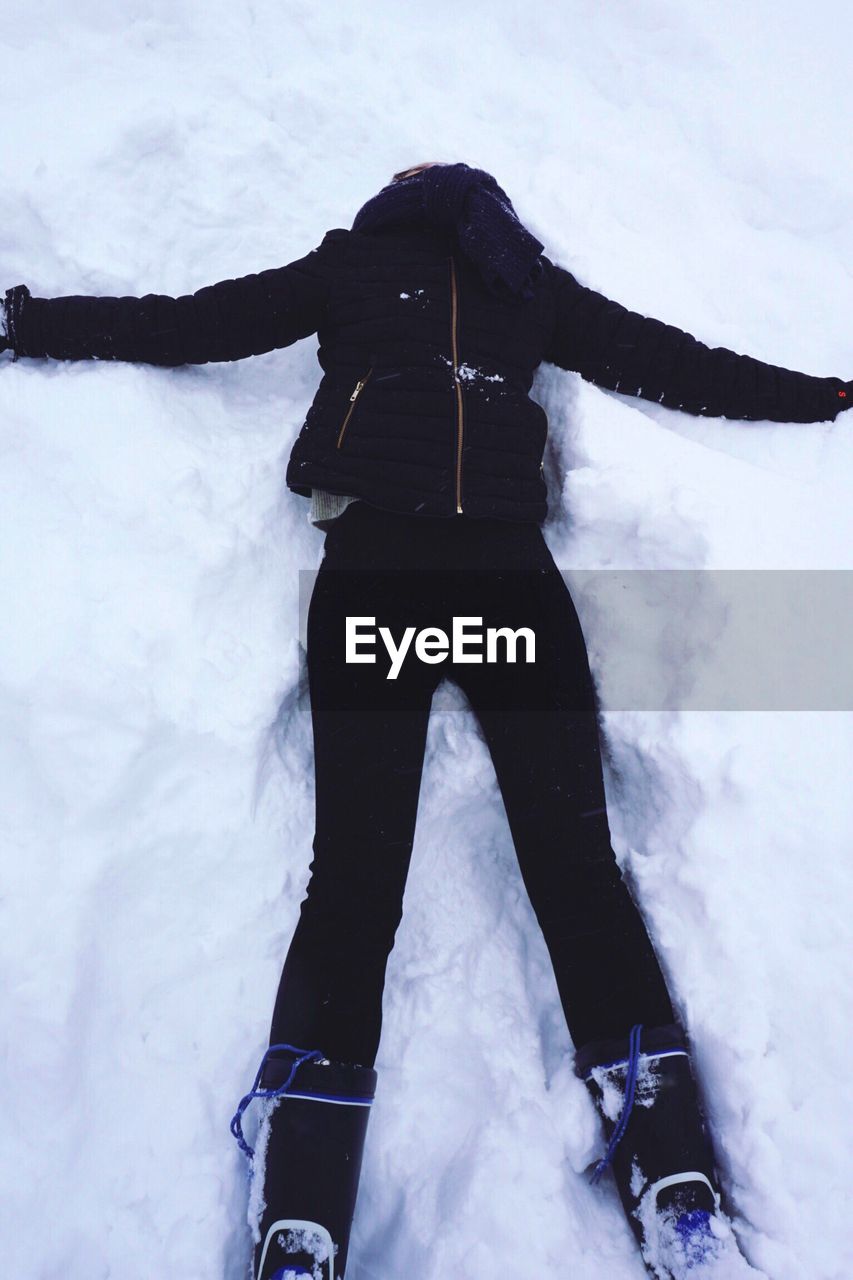 High angle view of woman lying down on snow